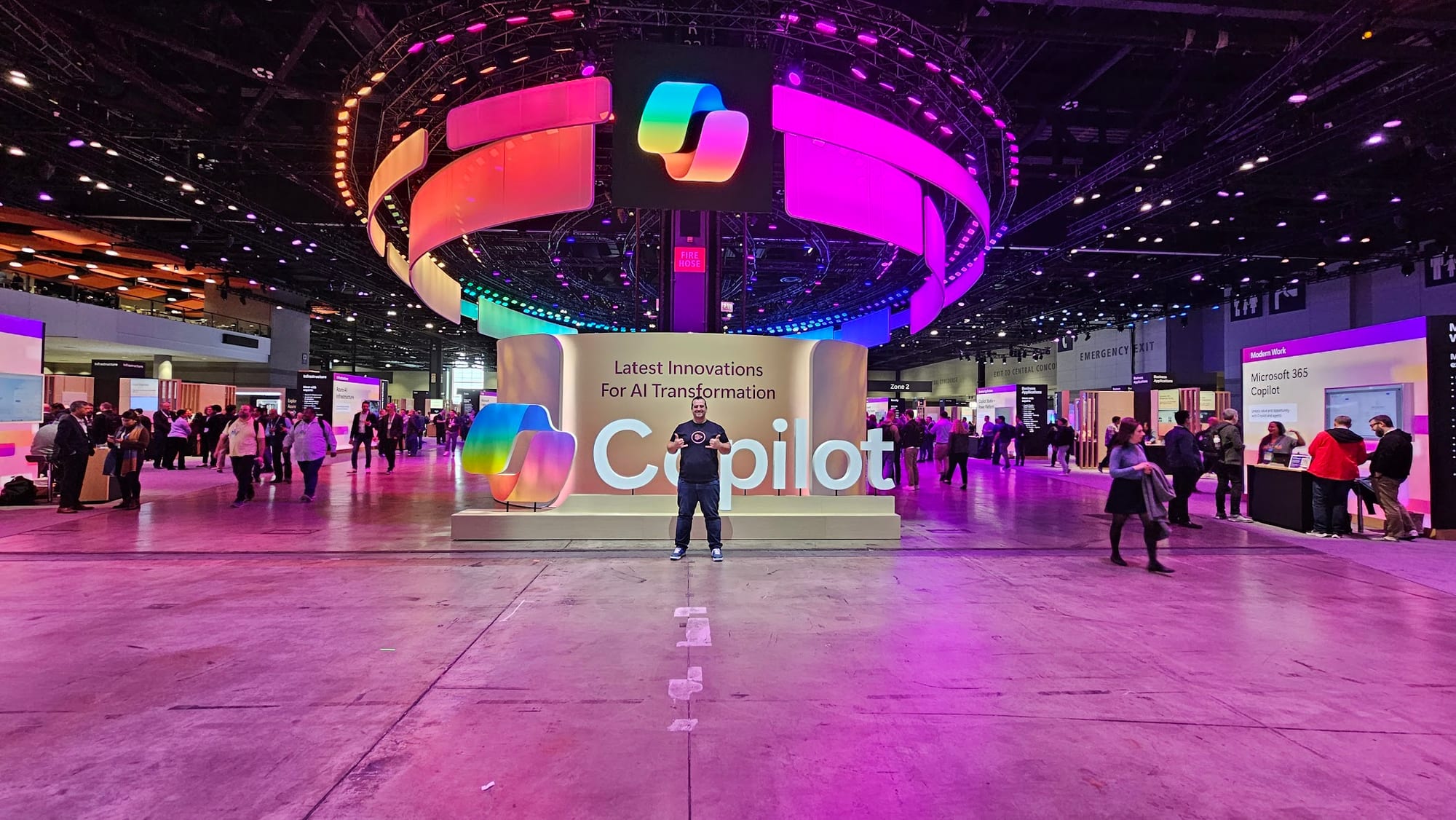 Vlad standing in front of the giant Copilot sign on the expo floor at Microsoft Ignite 2024 in Chicago