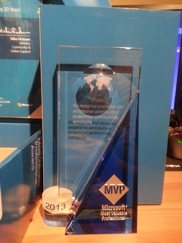 Microsoft Most Valuable Professional 2013 glass trophy standing on a desk in front of the blue MVP award box