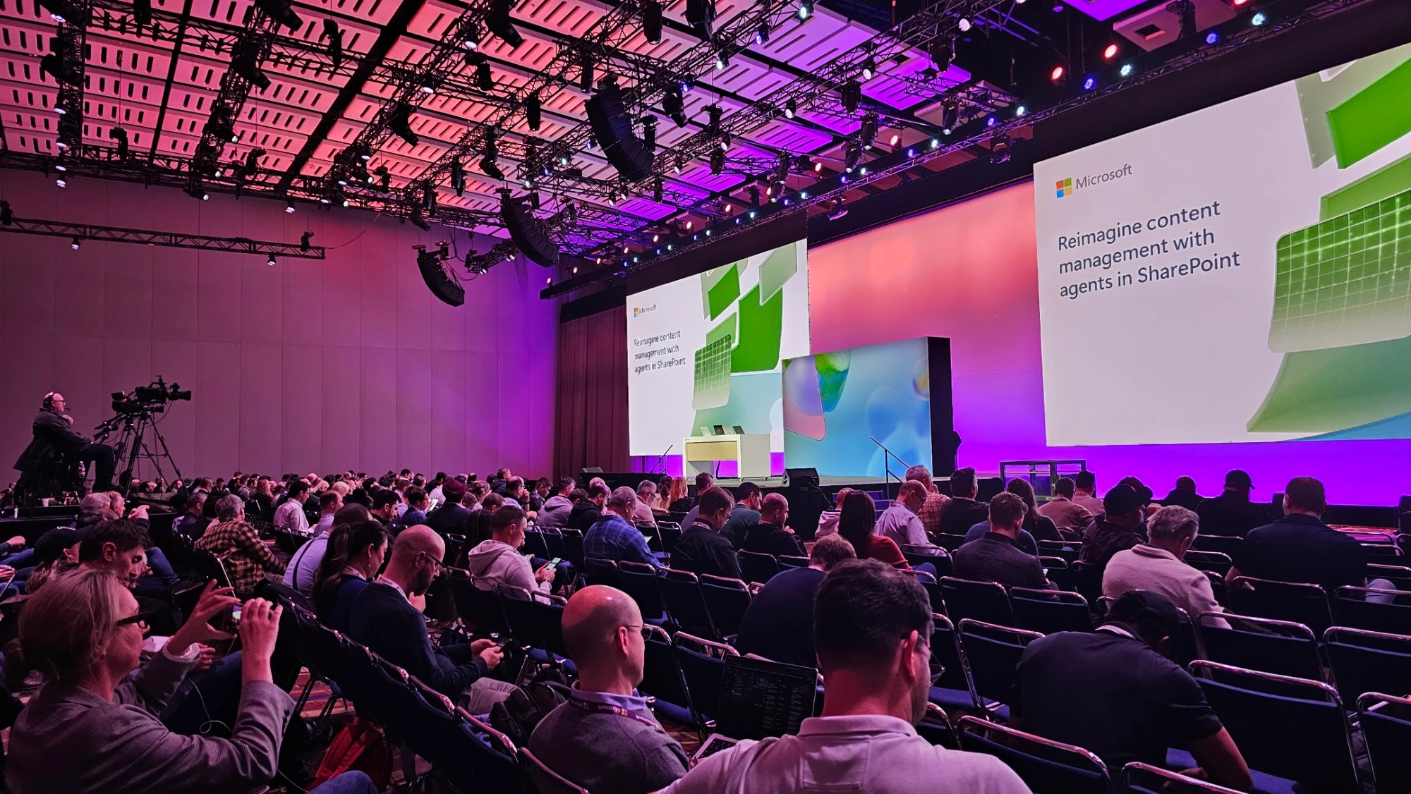 A large audience at Microsoft Ignite 2024 facing screens that read Reimagine content management with agents in SharePoint